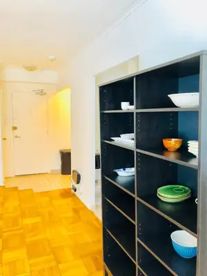 a black shelf with plates and bowls on it in a room at Stylish Montreal Apartment: Comfortable Stay in the Golden Square Mile in Montréal
