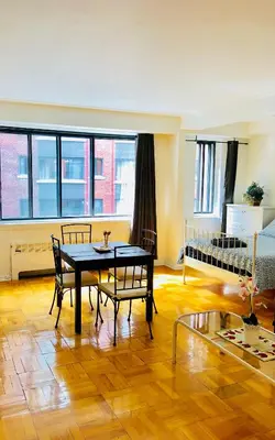 a living room with a table and chairs and a bedroom at Stylish Montreal Apartment: Comfortable Stay in the Golden Square Mile in Montréal