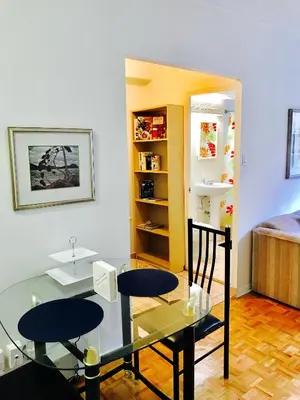 a room with two chairs and a glass table at Stylish Montreal Apartment: Comfortable Stay in the Golden Square Mile in Montréal