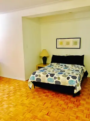 a bedroom with a bed and a wooden floor at Stylish Montreal Apartment: Comfortable Stay in the Golden Square Mile in Montréal