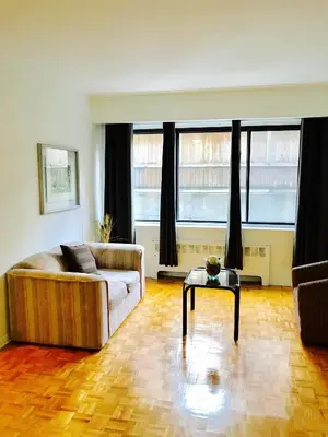 a living room with a couch and a table at Stylish Montreal Apartment: Comfortable Stay in the Golden Square Mile in Montréal
