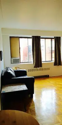 a living room with a couch and two windows at Stylish Montreal Apartment: Comfortable Stay in the Golden Square Mile in Montréal