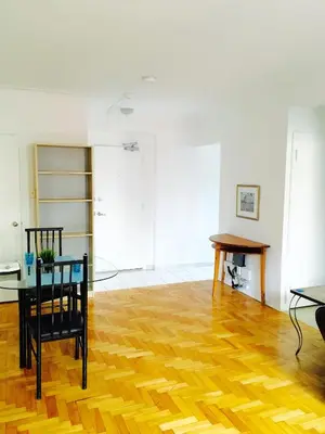 a living room with a table and a wooden floor at Stylish Montreal Apartment: Comfortable Stay in the Golden Square Mile in Montréal