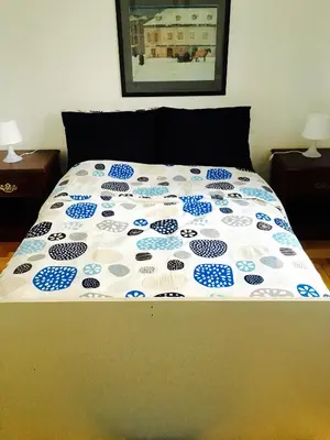 a bed with a blue and white comforter on it at Stylish Montreal Apartment: Comfortable Stay in the Golden Square Mile in Montréal