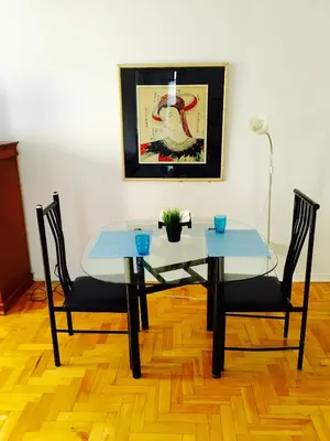 a dining table and two chairs and a table and a painting at Stylish Montreal Apartment: Comfortable Stay in the Golden Square Mile in Montréal