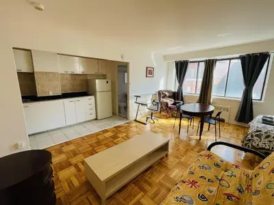 a kitchen and a living room with a table and chairs at Stylish Montreal Apartment: Comfortable Stay in the Golden Square Mile in Montréal