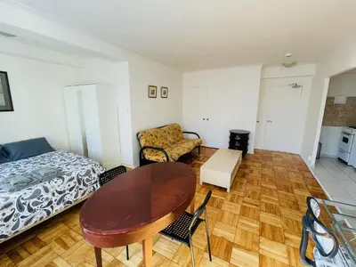 a bedroom with a table and a bed and a couch at Stylish Montreal Apartment: Comfortable Stay in the Golden Square Mile in Montréal