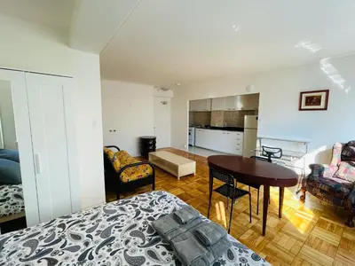 a room with a bed and a table and a kitchen at Stylish Montreal Apartment: Comfortable Stay in the Golden Square Mile in Montréal