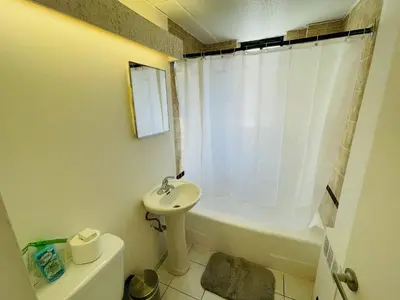 a bathroom with a sink and a tub and a toilet at Stylish Montreal Apartment: Comfortable Stay in the Golden Square Mile in Montréal