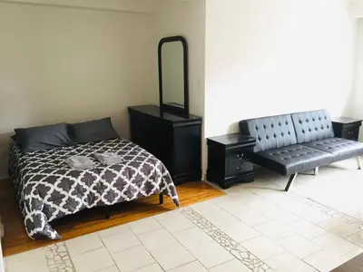 a bedroom with a bed and a mirror and a bench at Stylish Montreal Apartment: Comfortable Stay in the Golden Square Mile in Montréal