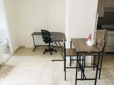 a room with two tables and a chair and a desk at Stylish Montreal Apartment: Comfortable Stay in the Golden Square Mile in Montréal