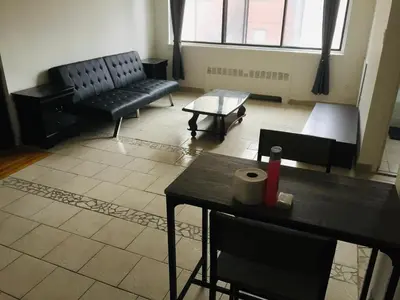 a living room with black furniture and a table at Stylish Montreal Apartment: Comfortable Stay in the Golden Square Mile in Montréal