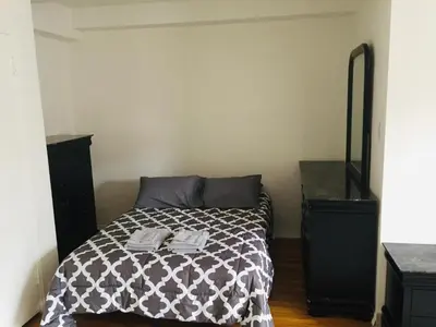 a bedroom with a bed with a black dresser at Stylish Montreal Apartment: Comfortable Stay in the Golden Square Mile in Montréal