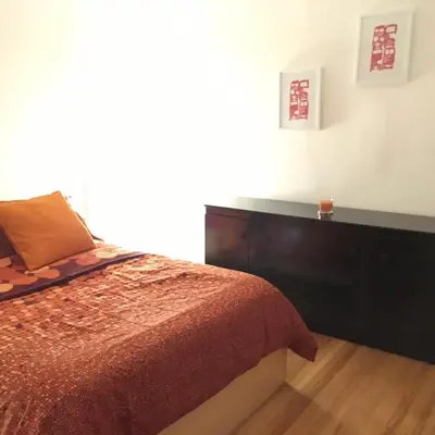 a bedroom with a bed with a red comforter at Stylish Montreal Apartment: Comfortable Stay in the Golden Square Mile in Montréal