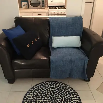 a brown leather couch with blue pillows on it at Stylish Montreal Apartment: Comfortable Stay in the Golden Square Mile in Montréal