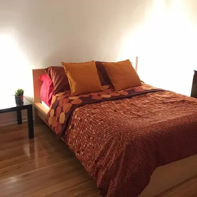 a bed with orange pillows and a brown blanket at Stylish Montreal Apartment: Comfortable Stay in the Golden Square Mile in Montréal