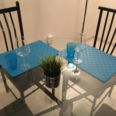 a glass table with three wine glasses and a plant on it at Stylish Montreal Apartment: Comfortable Stay in the Golden Square Mile in Montréal