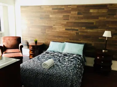 a bedroom with a bed and a wooden wall at Stylish Montreal Apartment: Comfortable Stay in the Golden Square Mile in Montréal