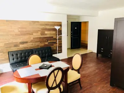 a living room with a couch and a table and chairs at Stylish Montreal Apartment: Comfortable Stay in the Golden Square Mile in Montréal