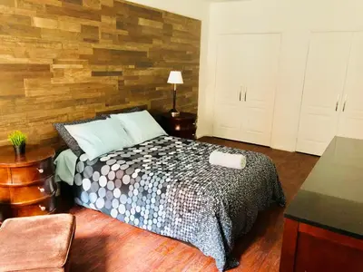 a bedroom with a bed and a wooden wall at Stylish Montreal Apartment: Comfortable Stay in the Golden Square Mile in Montréal