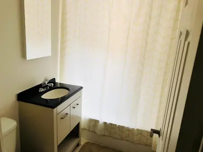 a bathroom with a sink and a shower curtain at Stylish Montreal Apartment: Comfortable Stay in the Golden Square Mile in Montréal