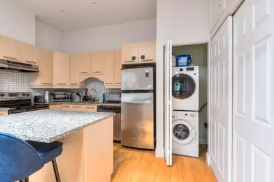 a kitchen with a refrigerator and a washer and dryer at Loft The White Pearl Plateau-Mont-Royal 3 Beds in Montréal