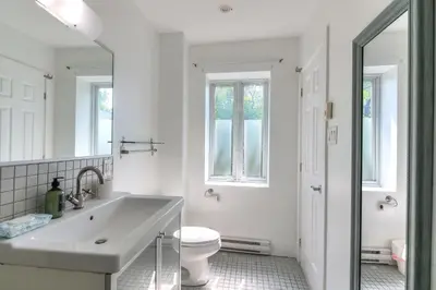 a white bathroom with a sink and a toilet at Loft The White Pearl Plateau-Mont-Royal 3 Beds in Montréal