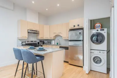 a kitchen with a washer and dryer at Loft The White Pearl Plateau-Mont-Royal 3 Beds in Montréal