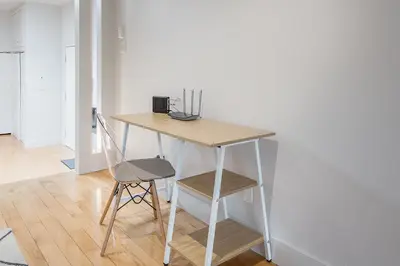 a wooden table with a chair next to a desk at Loft The White Pearl Plateau-Mont-Royal 3 Beds in Montréal