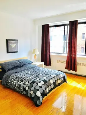 a bedroom with a bed and a large window at Stylish Montreal Apartment: Comfortable Stay in the Golden Square Mile in Montréal