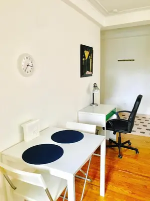 a room with a white table and a desk and a chair at Stylish Montreal Apartment: Comfortable Stay in the Golden Square Mile in Montréal