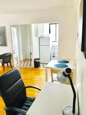 a living room with a chair and a table at Stylish Montreal Apartment: Comfortable Stay in the Golden Square Mile in Montréal
