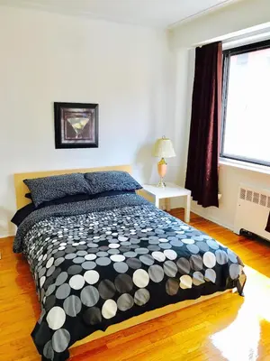 a bedroom with a black and white bed with a window at Stylish Montreal Apartment: Comfortable Stay in the Golden Square Mile in Montréal