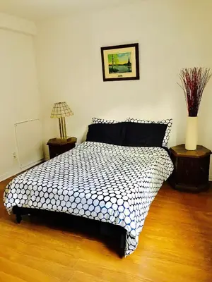 a bedroom with a black and white bed with two tables at Stylish Montreal Apartment: Comfortable Stay in the Golden Square Mile in Montréal