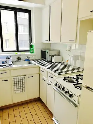 a kitchen with white cabinets and a stove top oven at Stylish Montreal Apartment: Comfortable Stay in the Golden Square Mile in Montréal