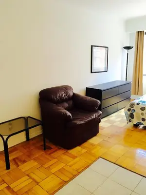 a living room with a brown leather chair and a table at Stylish Montreal Apartment: Comfortable Stay in the Golden Square Mile in Montréal