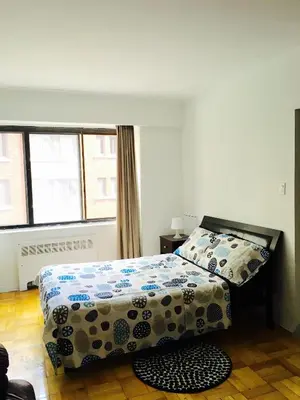 a bedroom with a bed and a window at Stylish Montreal Apartment: Comfortable Stay in the Golden Square Mile in Montréal