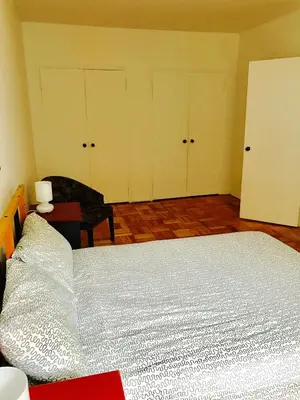a bedroom with a bed and two closets and a chair at Stylish Montreal Apartment: Comfortable Stay in the Golden Square Mile in Montréal