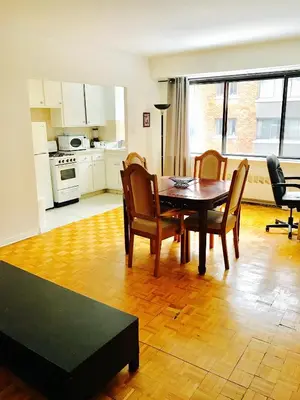 a kitchen and dining room with a table and chairs at Stylish Montreal Apartment: Comfortable Stay in the Golden Square Mile in Montréal
