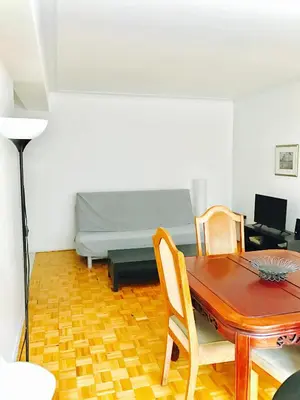 a living room with a table and a bed at Stylish Montreal Apartment: Comfortable Stay in the Golden Square Mile in Montréal