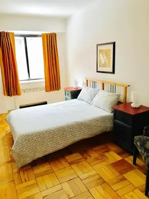 a bedroom with a large bed and a window at Stylish Montreal Apartment: Comfortable Stay in the Golden Square Mile in Montréal