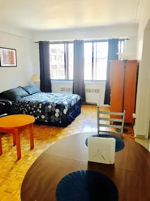 a living room with a bed and a table at Stylish Montreal Apartment: Comfortable Stay in the Golden Square Mile in Montréal
