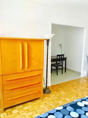 a wooden dresser in a living room with a table at Stylish Montreal Apartment: Comfortable Stay in the Golden Square Mile in Montréal