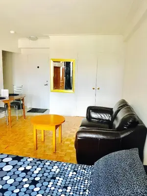 a living room with a leather couch and a table at Stylish Montreal Apartment: Comfortable Stay in the Golden Square Mile in Montréal