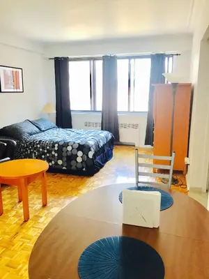 a living room with a bed and a table at Stylish Montreal Apartment: Comfortable Stay in the Golden Square Mile in Montréal
