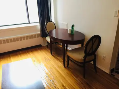 a table and chairs in a room with a window at Stylish Montreal Apartment: Comfortable Stay in the Golden Square Mile in Montréal