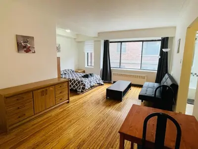 a bedroom with a bed and a table in a room at Stylish Montreal Apartment: Comfortable Stay in the Golden Square Mile in Montréal