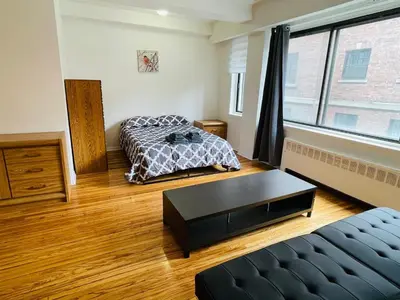a room with two beds and a table in it at Stylish Montreal Apartment: Comfortable Stay in the Golden Square Mile in Montréal