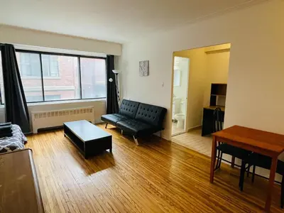 a living room with a couch and a table at Stylish Montreal Apartment: Comfortable Stay in the Golden Square Mile in Montréal