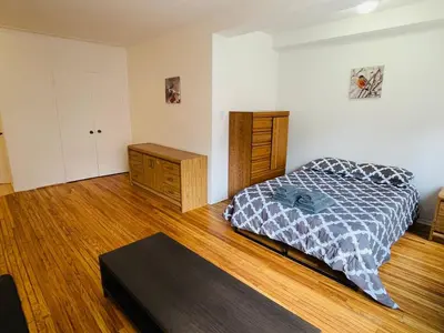 a bedroom with a bed and a wooden floor at Stylish Montreal Apartment: Comfortable Stay in the Golden Square Mile in Montréal